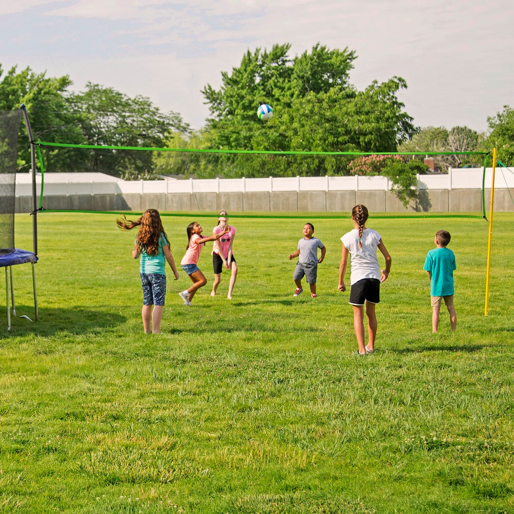 Six young children playing volleyball with the Volleyball Net Accessory.