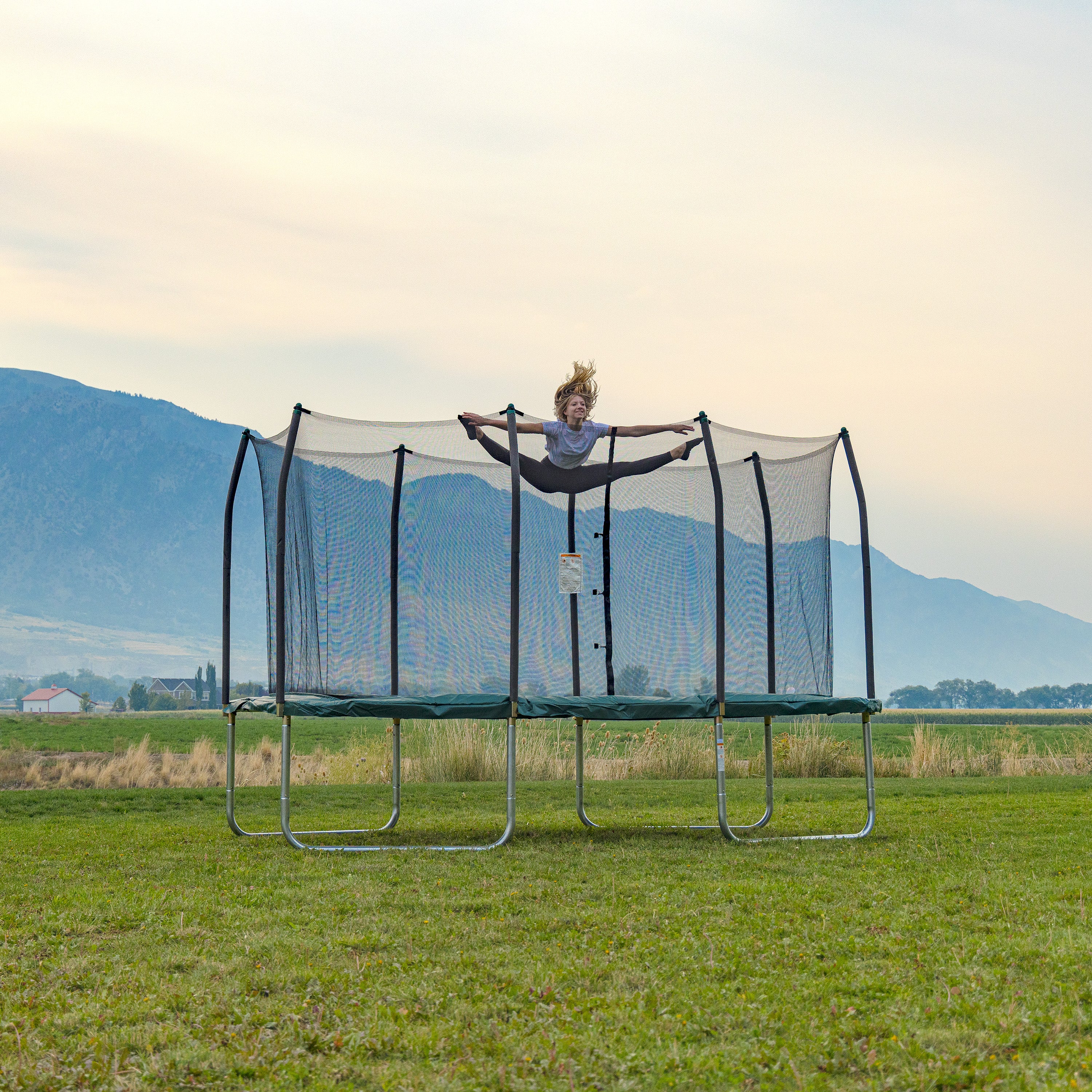 Teenage girl does the jumping splits on the 14-foot rectangle trampoline.