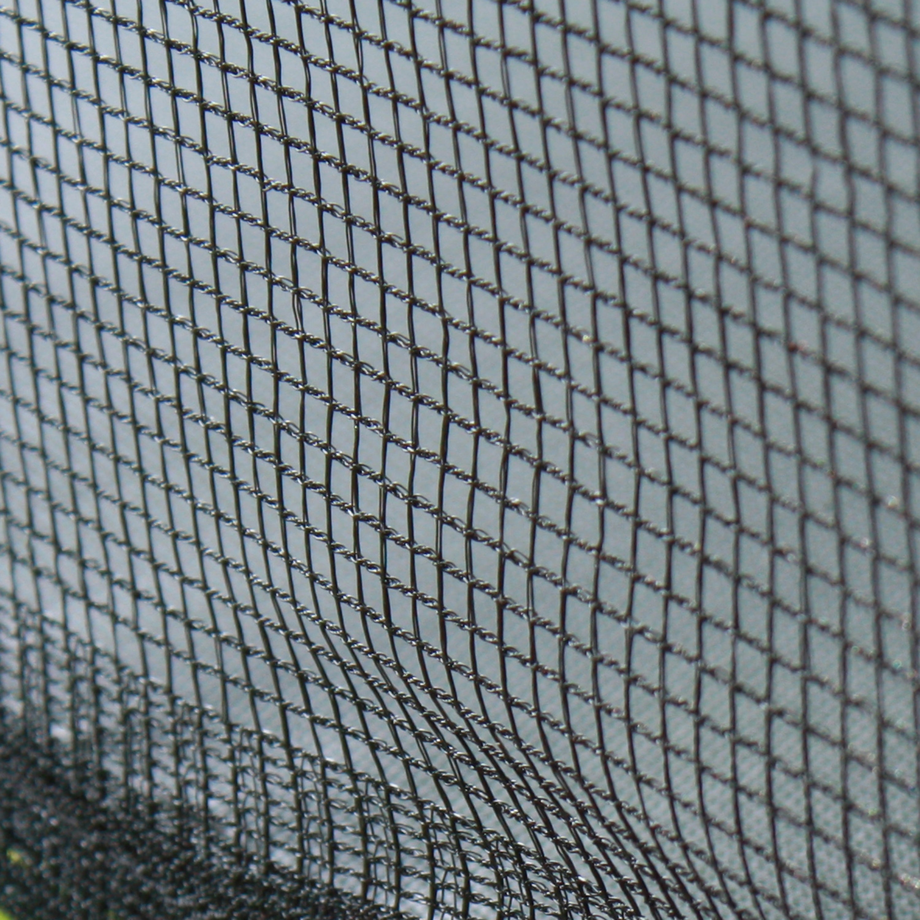 Close-up view of the polyethylene weave of the enclosure net. 