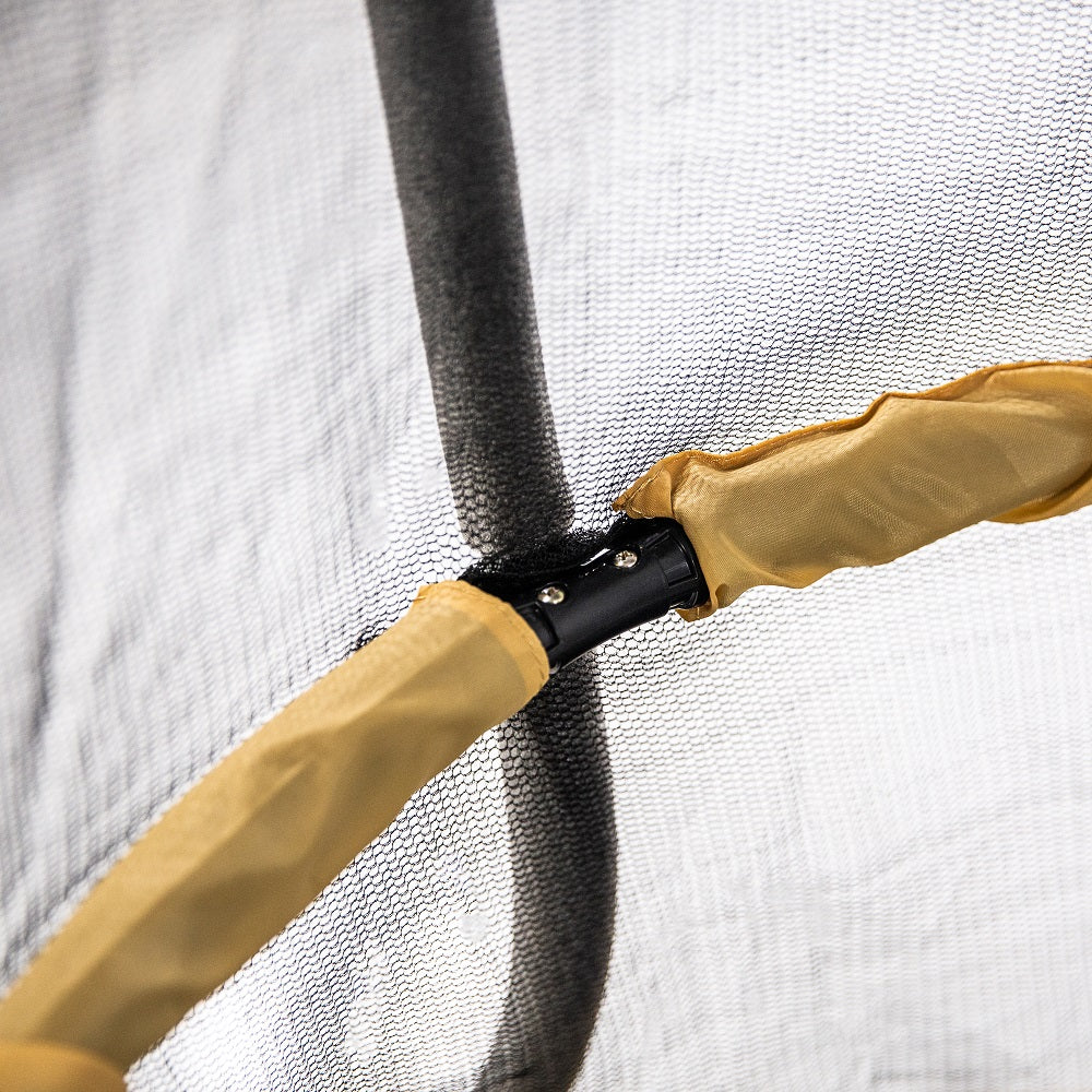 Close-up view of the yellow handlebar inside of the mini trampoline's enclosure. 