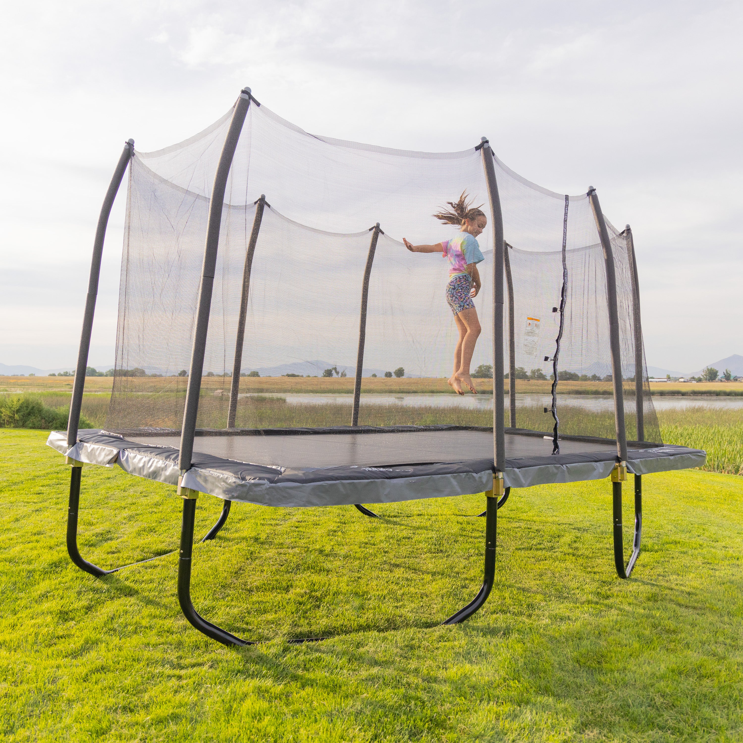 Girl spins in a circle while jumping on the 9 by 15 foot rectangle Epic Trampoline. 
