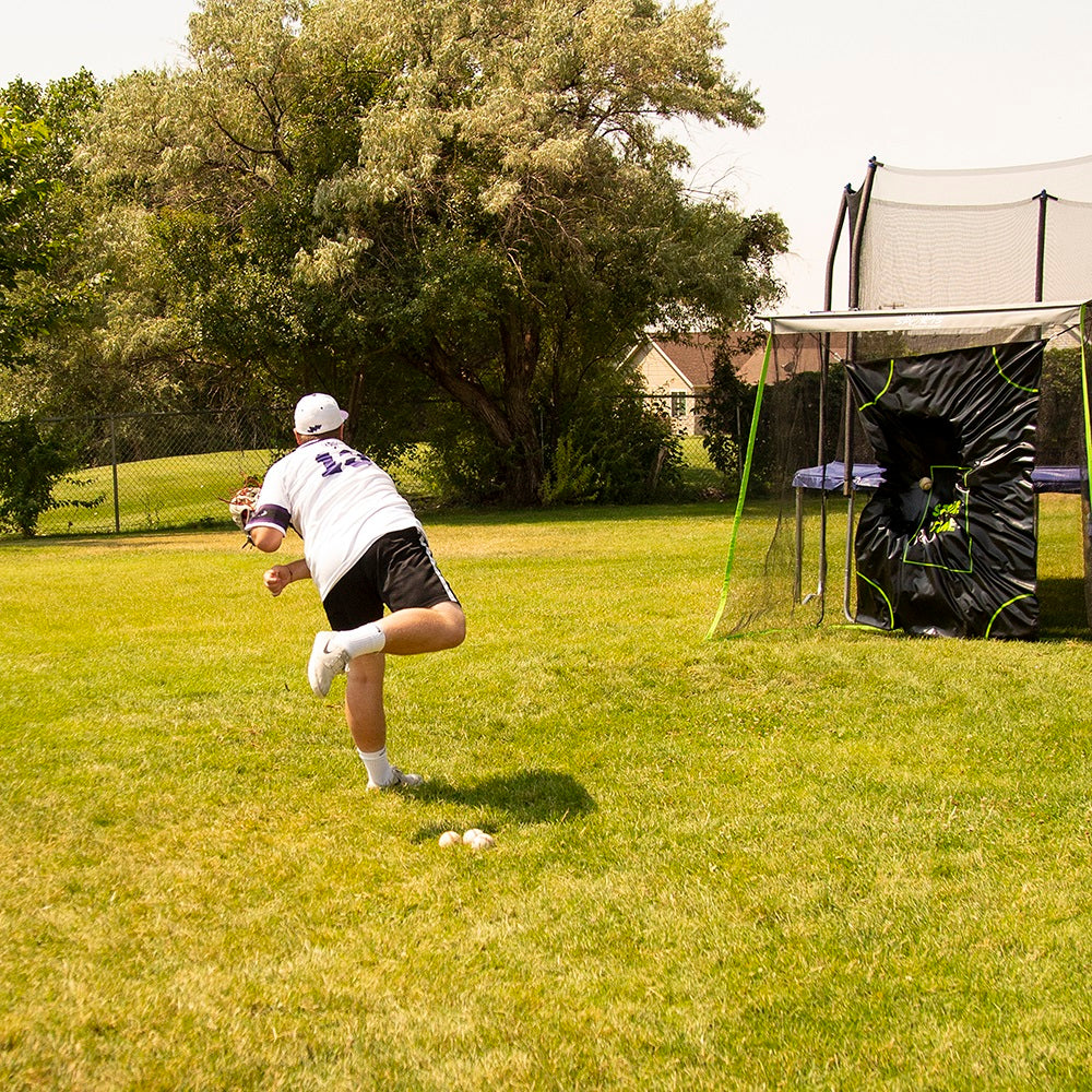 Boy throws baseball at the Multi-Sport Training Net's target zone mat. 