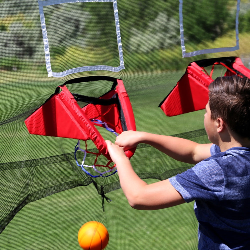 A boy pulls on the breakaway rim of the basketball hoop. 