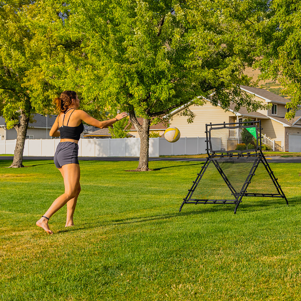 Volleyball player hits a volleyball towards the Multi-Sport Rebounder. 