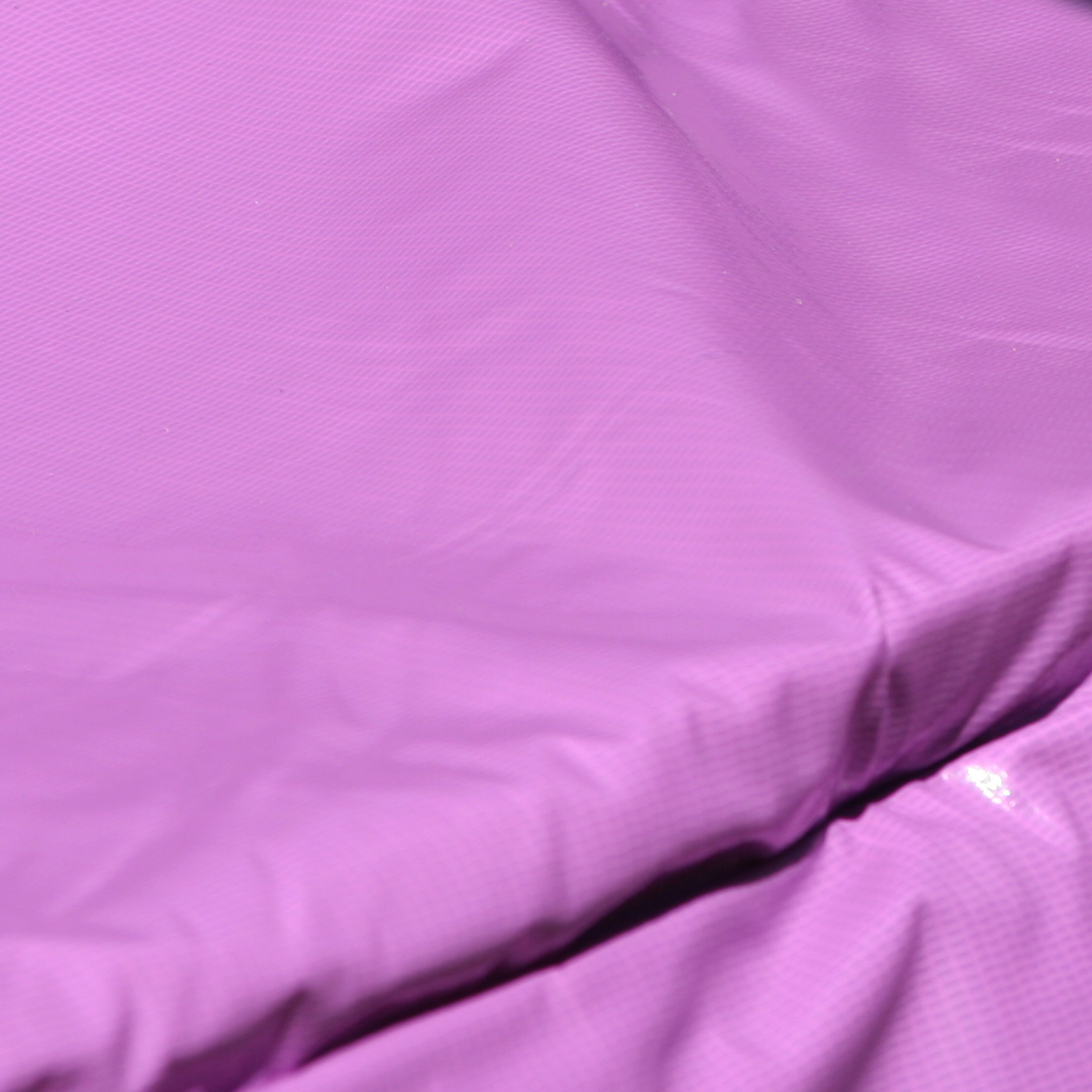 Close-up view of the purple, vinyl-coated, weather-resistant spring pad. 